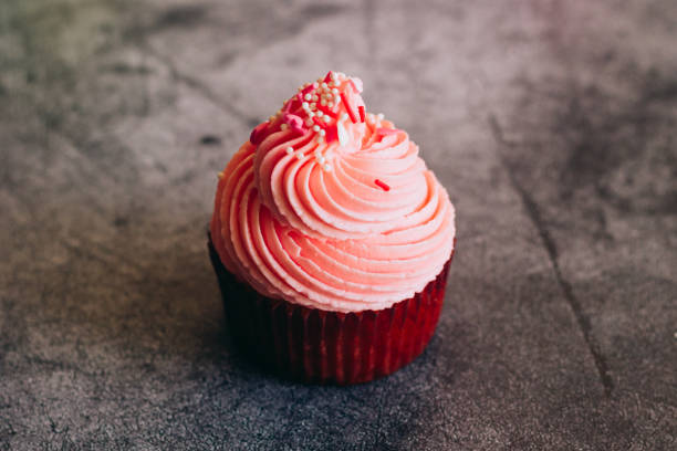 istock Delicious cupcakes. Cupcakes on a concrete table 1353811165