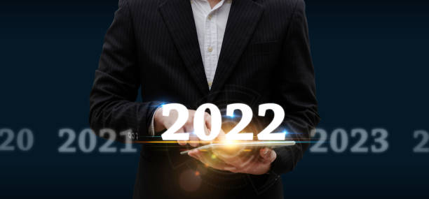 istock Business Trend. smart businessman investor using mobile tablet with virtual screen on dark background, change from 2021 to 2022, strategy, investment, business planning and happy new year concept 1353811389