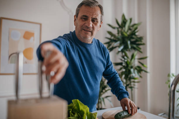 istock Home cooking, a man cuts vegetables 1353811438