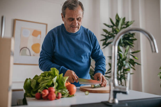 istock Home cooking, a man cuts vegetables 1353811440