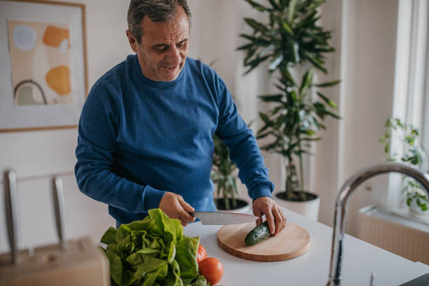 istock Home cooking, a man cuts vegetables 1353811481