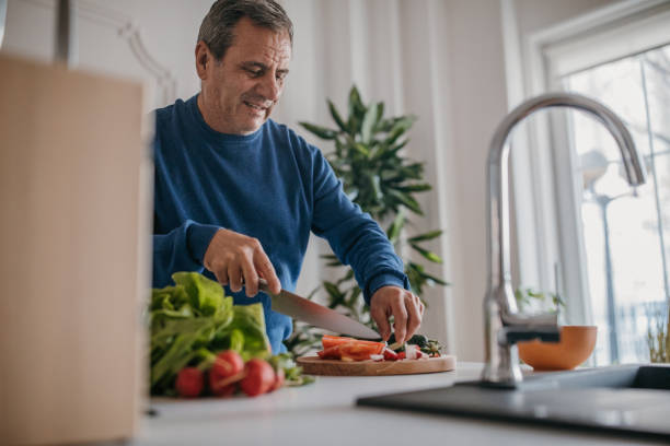 Home cooking, smiling chef cutting vegetables