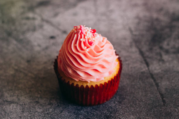 istock Delicious cupcakes. Cupcakes on a concrete table 1353811662