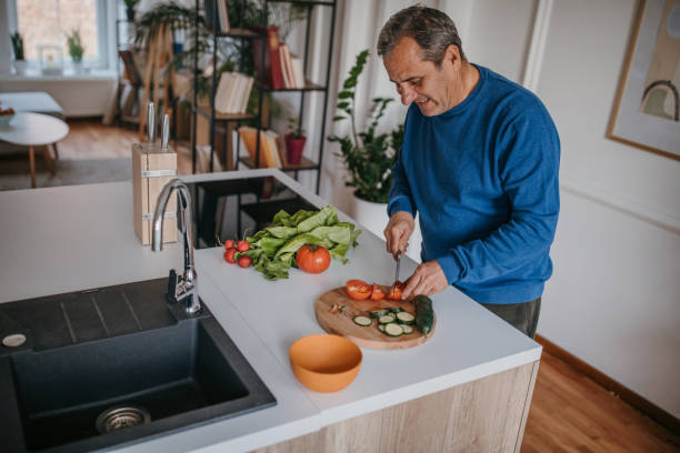 istock Home cooking, smiling chef cutting vegetables 1353811725