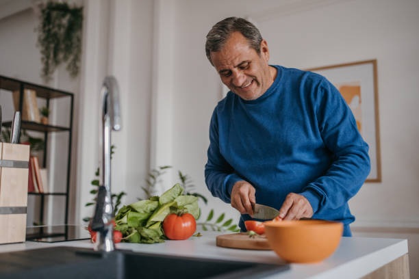 istock Home cooking, smiling chef cutting vegetables 1353812825