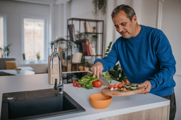 istock Home cooking, a man cuts vegetables 1353813181