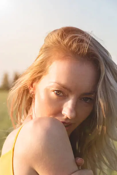 Portrait of a beautiful woman at sunset in a field