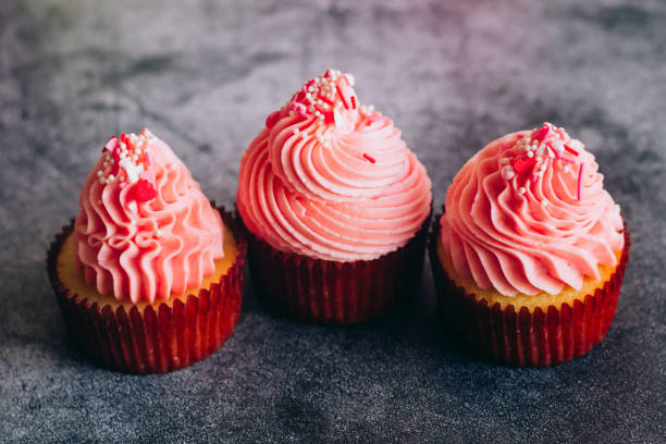istock Delicious cupcakes. Cupcakes on a concrete table 1353814290