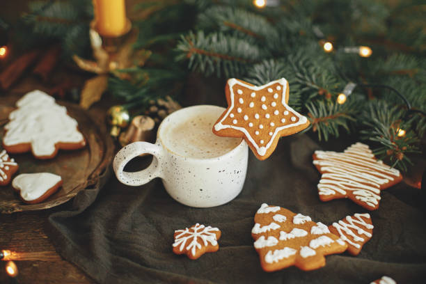 istock Christmas gingerbread cookies, coffee, fir branches on rustic table. Christmas star. Winter time 1353814955