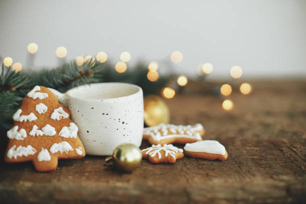 istock Christmas gingerbread cookies, coffee, fir branches on rustic table with lights. Merry Christmas 1353815963