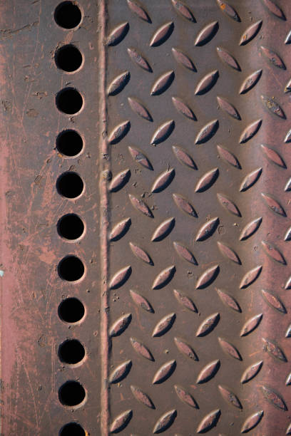 Detail (close-up) of old, broken, weathered, rusty, door of a black painted abandoned American made (1960s) car.
