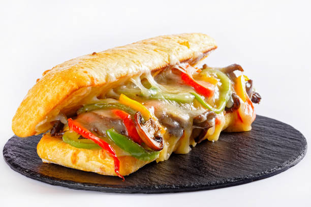 istock Philly cheese steak sandwich with roasted beef, pepper, caramelized onion, mushrooms and melted cheese on a black stone board 1353820639