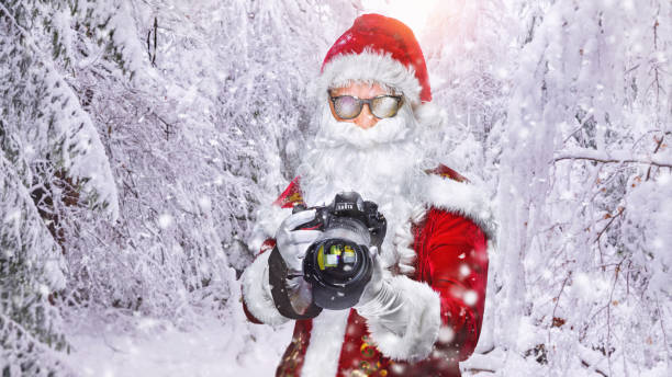 genial santa claus tomando fotos de vacaciones en el paisaje nevado - only men senior men snow tripod fotografías e imágenes de stock