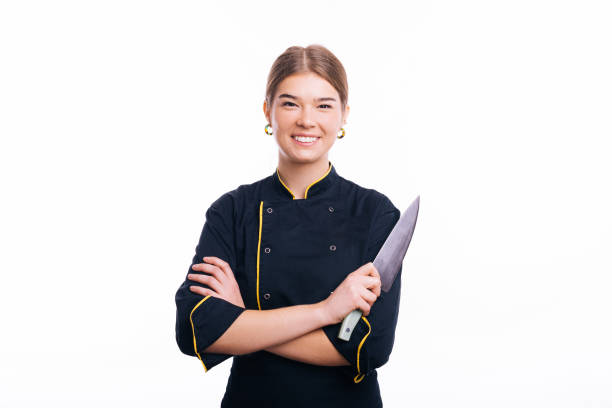 Portrait of a young woman chef cook holding knife isolated on a white background stock photo
