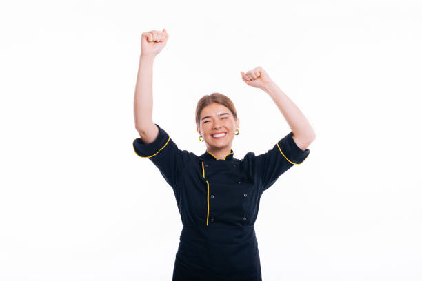 Young beautiful baker woman wearing uniform cooking over white background celebrating for success with arms raised stock photo
