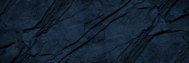 Photo of Black blue rock texture. Toned mountain surface. Macro. Dark volumetric stone background