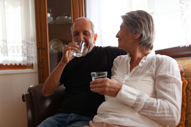 istock Senior women holding water, senior men drinking water. 1353824512