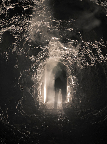Silhouette of a man walking down the tunnel, blurred motion