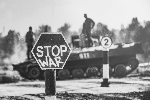 Creative Badge - Stop Wars. Concept - no war, stop military operations, world peace. Stop war sign on the background of military equipment