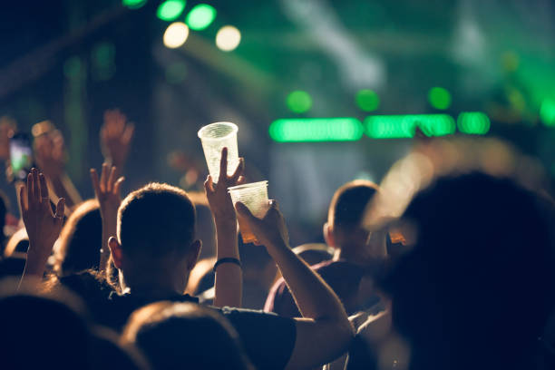 Person holding cold beer plastic cup on a music festival. Person holding cold beer plastic cup on a music festival. festival goer stock pictures, royalty-free photos & images
