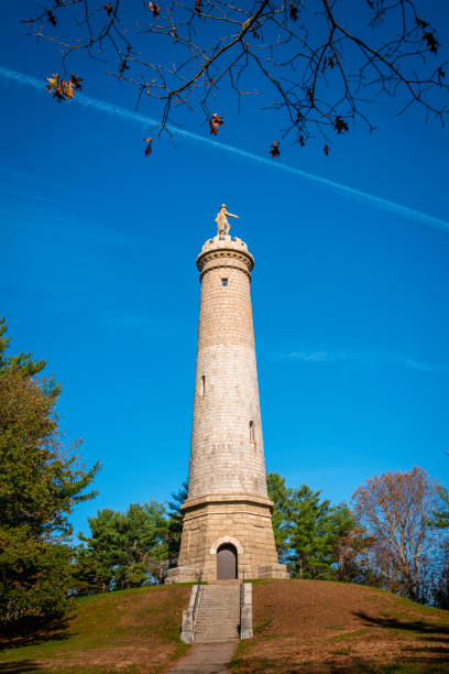istock Myles Standish Monument in the woods on blue sky background. 1353836731