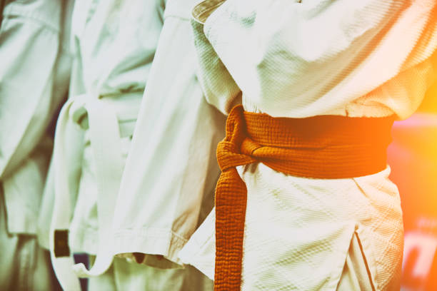 istock Concept karate, martial arts. Construction of students in the hall before training. Kimono, different belts, different levels of training 1353836998