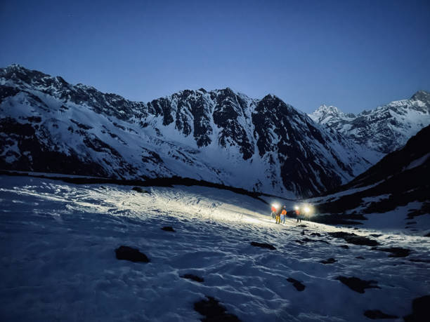 istock Friends backcountry ski up snow slope before dawn 1353838201