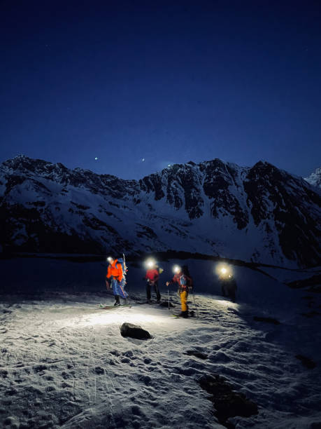 istock Friends backcountry ski up snow slope before dawn 1353838541
