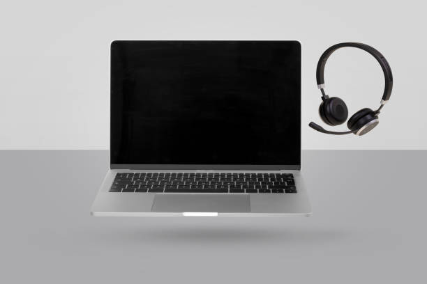istock Laptop  computer with empty screen and headset  levitating in the air on a gray background. Creative minimal background. 1353840604