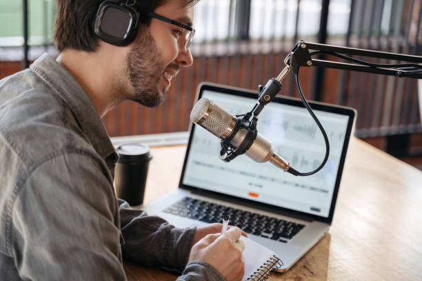 istock Man host broadcasting audio podcast in studio. Close up 1353841286