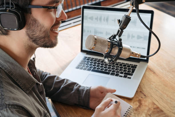 istock Caucasian man recording a podcast on his laptop computer with headphones and microscope 1353842906