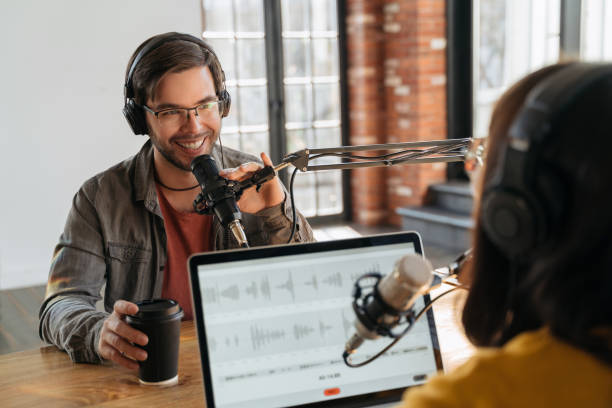 istock Cheerful man gives an interview for live audio podcast in studio 1353844291