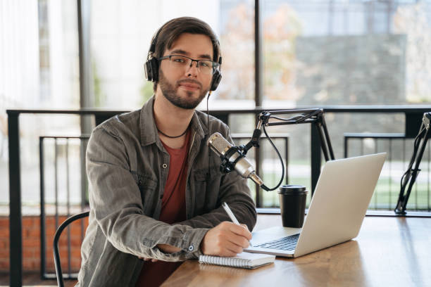 istock Young male podcaster looking at camera and smiling 1353844848