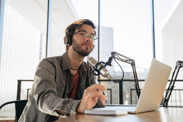 istock Man host recording his audio podcast in studio 1353846129