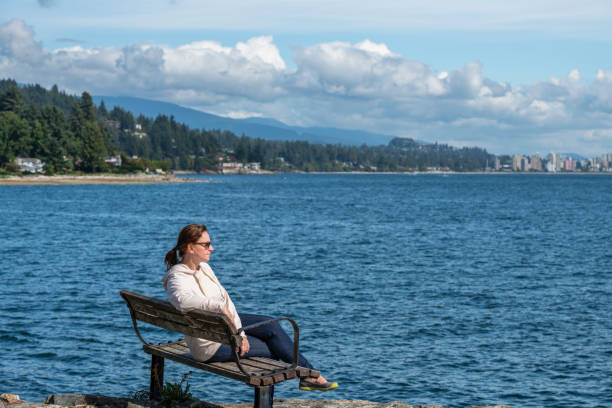 istock Female hiker relaxes on coastal cliff, in autumn 1353846579