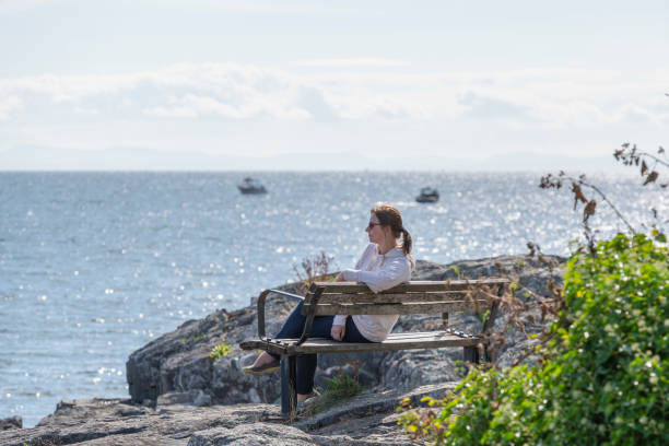 istock Female hiker relaxes on coastal cliff, in autumn 1353847169
