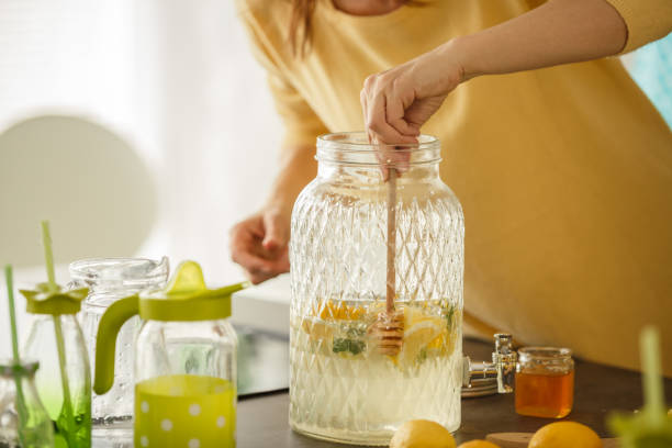 frau süßt limonade mit honig - zitronensaft stock-fotos und bilder