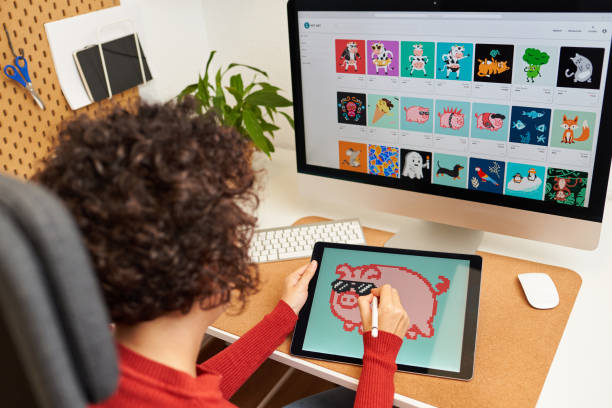 NFT artist painting on a digital tablet in his home office Female digital artist painting on a digital tablet creating NFT crypto art for marketplace non-fungible token non fungible token stock pictures, royalty-free photos & images