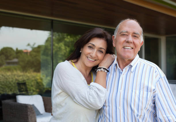 Smiling couple standing on patio  baby boomer stock pictures, royalty-free photos & images