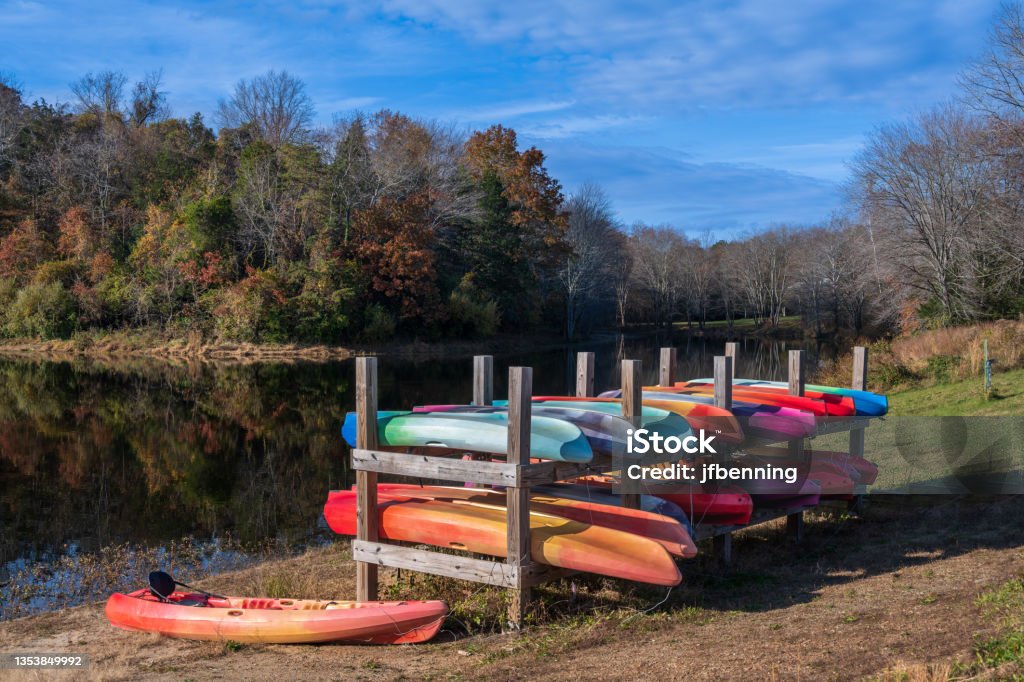 Colorful Canoes by a Lake Photo of colorful canoes in a stand by a lake in Autumn. Reston Stock Photo