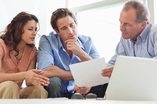 Couple going over paperwork with financial advisor  how to sell my photography online stock pictures, royalty-free photos & images