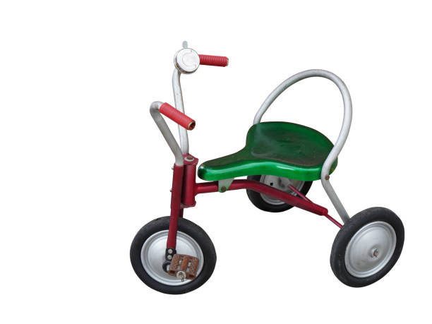 red and green old children bicycle with three wheels isolated, copy space