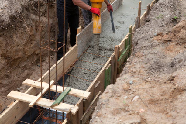 istock Construction of building foundation. Pouring with liquid concrete of formwork with reinforced iron. Construction home. 1353850975
