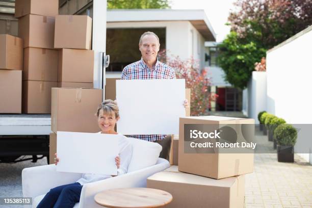 Pareja Sosteniendo Tarjetas En Blanco Cerca De Cajas Y De Las Mudanzas Foto de stock y más banco de imágenes de Dos personas