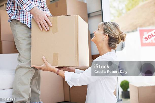 Husband Handing Box To Wife From Moving Van Stock Photo - Download Image Now - Loading, Relocation, Senior Adult