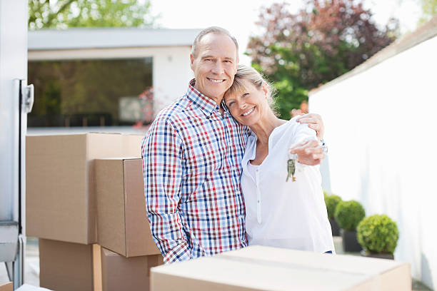 Couple hugging near stack of moving boxes  Hove stock pictures, royalty-free photos & images
