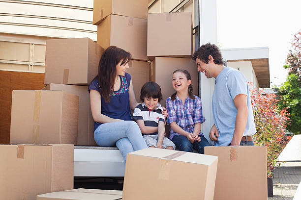 Family sitting on back of moving van  Hove stock pictures, royalty-free photos & images