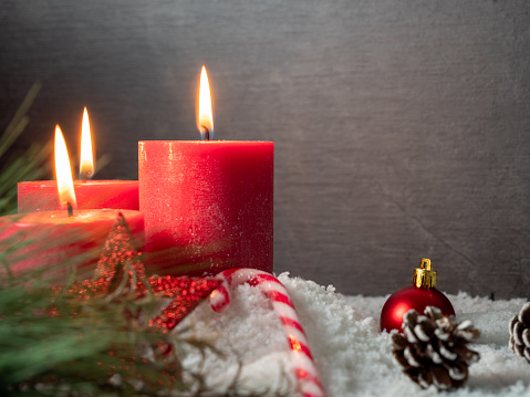 Red Christmas candle and Christmas decorations on a gray background. High quality photo