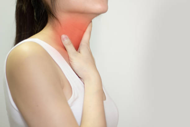 Asian woman using touch throat with pain, sore throat and sickness in an inflaming. Asian woman using touch throat with pain, sore throat and sickness in inflaming. thyroid disease stock pictures, royalty-free photos & images