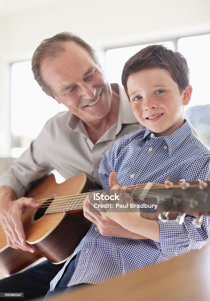 Dziadek nauczania Wnuk grać na gitarze - Zbiór zdjęć royalty-free (Dziadek)